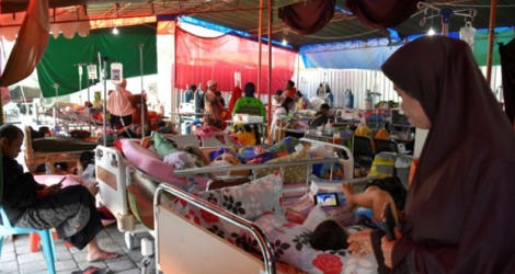 Des blessés et leurs familles dans un hôpital de fortune à Mataram le 20 août 2018, sur l'île de Lombok en Indonésie, touchée par de multiples séismes.