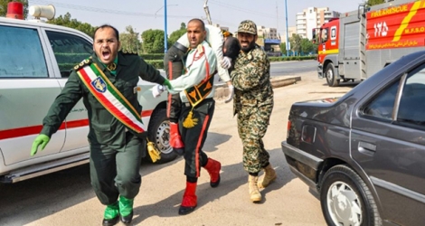 Un homme porte un soldat blessé lors d'une attaque à Ahvaz, dans le sud-ouest de l'Iran, le 22 septembre 2018