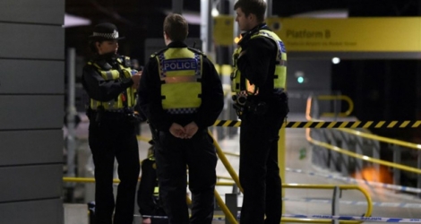 Des policiers se tiennent dans la gare de Manchester où s'est déroulée l'attaque au couteau, dans la nuit du 31 décembre 2018 au 1er janvier 2019.