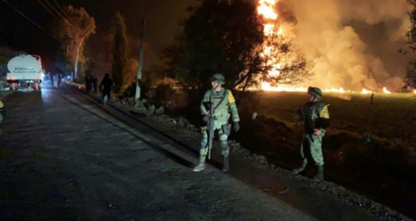 Des soldats se tiennent près du feu provoqué par un oléoduc, à Tlahuelilpan (centre du Mexique) le 18 janvier 2019.