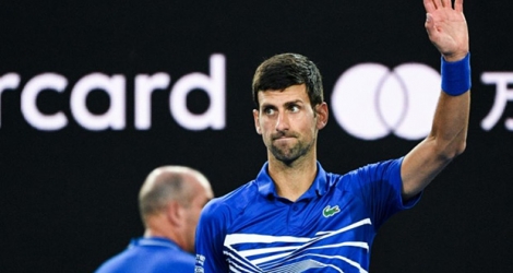 Le Serbe Novak Djokovic bras levé après sa victoire face au Japonais Kei Nishikori en quarts de finale de l'Open d'Australie, le 23 janvier 2019 à Melbourne