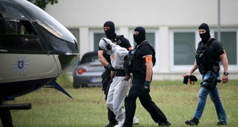 Des policiers conduisent l'Irakien Ali Bashar, soupçonné de meurtre, vers un hélicoptère devant le ramener en prison après un interrogatoire à Wiesbaden, en Allemagne, le 10 juin 2018.
