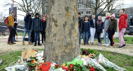 Des adolescents déposent des fleurs sur le site de la fusillade qui a fait trois morts lundi 18 mars 2019 à Utrecht, aux Pays-Bas.