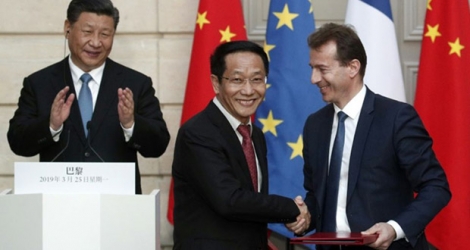 Le président chinois Xi Jinping (g) applaudit la signature d'un accord commercial entre le président d'Airbus Guillaume Faury (d) et le patron de la China Aviation Supplies Holding Compagny (CASC) Jia Baojun, le 25 mars 2019 à l'Elysée, à Paris.