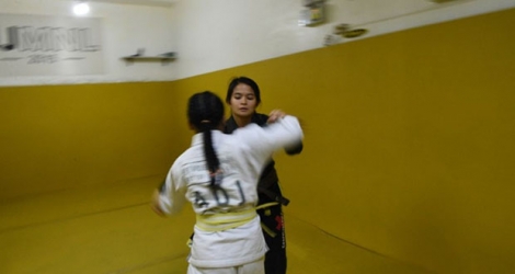 La championne du monde philippine de jiu-jitsu Meggie Ochoa (d) lors d'une session d'entraînement avec une jeune fille, le 2 avril 2019 à Manille.