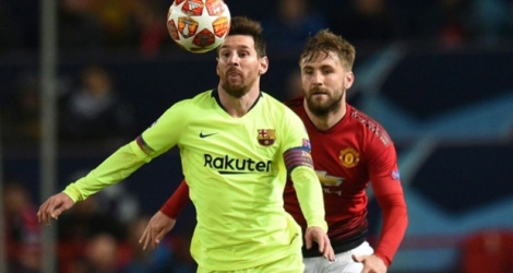 L'attaquant et capitaine du FC Barcelone Lionel Messi (c) aux prises avec le défenseur de Manchester United Luke Shaw (d) en quart de finale aller de la Ligue des champions, le 10 avril 2019 à Manchester.