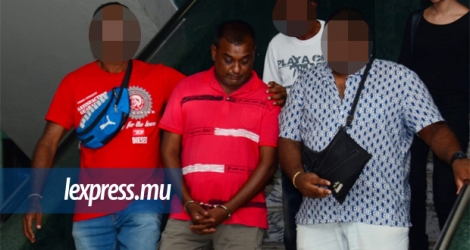 Le suspect Sanjaye Koonjal (en rouge, au centre), lors de sa comparution en cour intermédiaire, hier.
