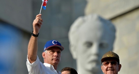 Le président cubain Miguel Diaz-Canel (g) agite un drapeau devant l'ancien président Raul Castro, lors des célébrations du 1er mai 2018 à La Havane.