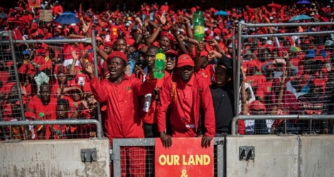 Des Sud-Africains du parti EFF participent au dernier meeting du parti le 5 mai 2019 devant une affiche o l'on peut lire: «notre terre et des emplois maintenant».