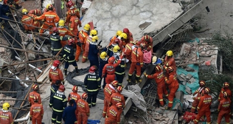 Des équipes de secours recherchent des victimes après l'effondrement d'un immeuble à Shanghai, le 16 mai 2019 en Chine.