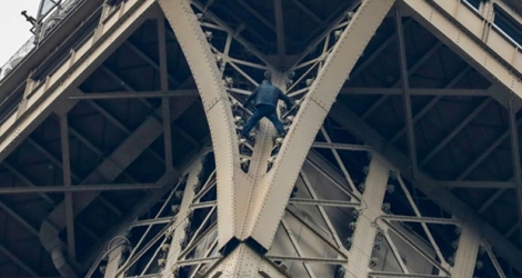 Un homme grimpe la tour Eiffel le 20 mai 2019 à Paris.