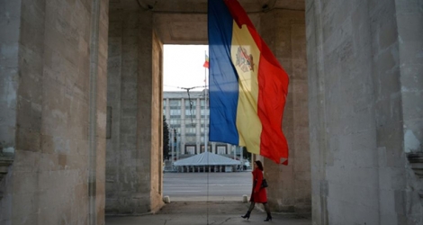 Une femme marche au pied d'un drapeau moldave à Chisinau, le 8 octobre 2013.