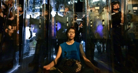 Une femme médite devant les forces de l'ordre, le 12 juin 2019 à Hong Kong.