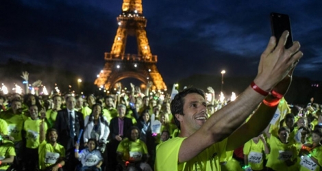 Le patron du Comité d'organisation de Paris-2024 Tony Estanguet prend un selfie avec les participants à la Journée olympique, le 23 juin 2018 à Paris.