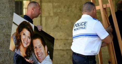 Un policier tient le portrait de ses collègues tués à Magnanville le 13 juin 2016, lors d'un hommage à Pézenas (Hérault), le 20 juin 2016.