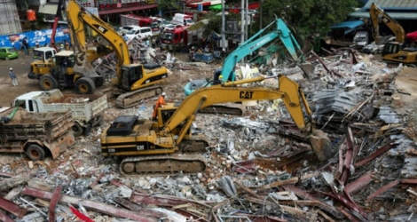 Des secouristes déblaient les décombres d'un immeuble en construction qui s'est effondré à Sihanoukville le 23 juin 2019.