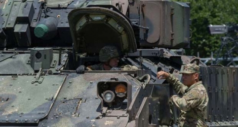 Deux militaires discutent sur un véhicule de combat avant un défilé à Washington, le 4 juillet 2019.
