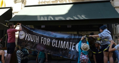 Des militants du mouvement les jeunes pour le climat affichent une banderole devant un restaurant McDonald's à Bordeaux le 14 juillet 2019 Photo MEHDI FEDOUACH. AFP