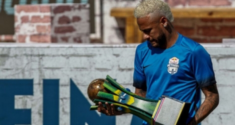 Le joueur de football Brésilien Neymar tenant un trophée lors d'un tournoi de football à cinq au bénéfice de sa fondation basée à Praia Grande (sud-est du Brésil), le 13 juillet 2019.