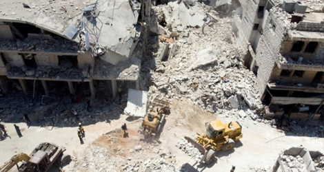 Les secouristes s'activent au pied d'un immeuble détruit par un bombardement, à Maaret al-Noomane, dans le nord-ouest de la Syrie, le 22 juillet 2019.