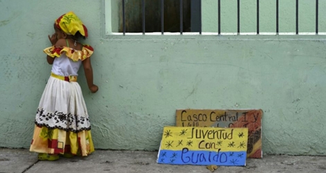 Une fillette vénézuélienne en costume traditionnel à côté d'une pancarte sur laquelle est écrit : «La jeunesse avec Guaido», à Barlovento dans l'Etat de Miranda le 6 juillet 2019.