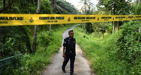 Un policier marche près d'un cordon de sécurité à l'entrée du complexe touristique à Seremban en Malaisie le 13 août 2019.
