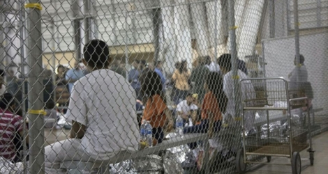 Des enfants et des adultes ayant traversé la frontière illégalement, attendent au centre de rétention McAllen au Texas, le 17 juin 2018.