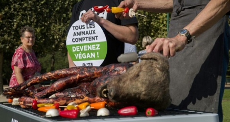 Des activistes de Peta organisent une action devant la Tour Eiffel, où un faux chien est installé sur un barbecue, le 23 août 2019.