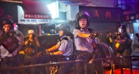 Des policiers pointent leurs armes sur des manifestants, le 25 août 2019 à Hong Kong.