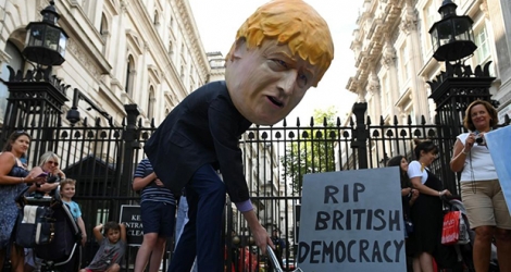 Un manifestation porte un masque représentant le Premier ministre britannique Boris Johnson, lors d'une protestation devant le Downing Street le 28 août, au lendemain de sa décision de suspendre le parlement jusqu'au 14 octobre. 
