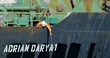 Photo prise 18 août 2019, montrant un membre d'équipage vérifiant le nouveau nom du pétrolier iranien Adrian Darya, connu auparavant sous le nom de Grace 1, au large des côtes de Gibraltar.