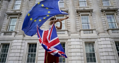 Un manifestant anti-Brexit fait tournoyer des drapeaux européen et britannique lors d'une manifestation à Londres le 31 août 2019.