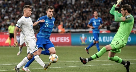 Le jeune milieu italien Nicolo Barella (g), 22 ans, tente de battre le gardien grec Vasilios Barkas (d) lors d'un match pour les qualifications à l'Euro-2020, au stade olympique d'Athènes le 8 juin 2019. 
