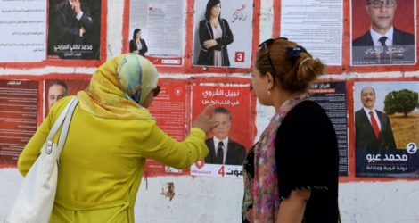 Des Tunisiennes regardent des affiches électorales dans le cadre de la campagne pour la présidentielle anticipée du 15 septembre 2019, le 2 septembre 2019 à Tunis.