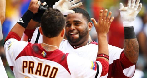 Les Vénézuéliens Pablo Sandoval et Martin Prado se congratulent lors d'un match de baseball contre l'Espagne à San Juan, au Porto Rico, le 10 mars 2013.