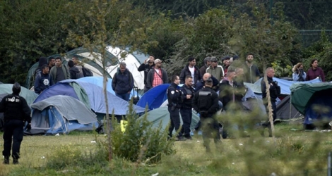 Des gendarmes devant des tentes lors de l'évacuation du campement de migrants de Grande Synthe le 17 septembre 2019.