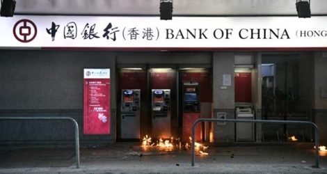 Des cocktails molotov lancés par des manifestants le 1er octobre 2019 brûlent devant des guichets de la Bank of China à Hong Kong.