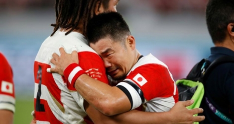 Le demi de mêlée japonais Fumiaki Tanaka (D) enlace son coéquipier Shota Horie après la défaite du Japon face à l'Afrique du Sud en quart de finale de la Coupe du monde de rugby au Japon, le 20 octobre 2019.