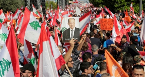 Le portrait du président Michel Aoun est brandi au milieu d'une forêt de drapeaux libanais, lors d'une manifestation de soutien au chef de l'Etat, le 3 novembre 2019 à Baabda, au sud-est de Beyrouth.