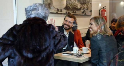 Pablo Casado, chef de file du Parti populaire (PP, conservateur), assis avec sa femme Isabel Torres dans une cafétéria après avoir voté, salue une femme à Madrid le 10 novembre 2019.