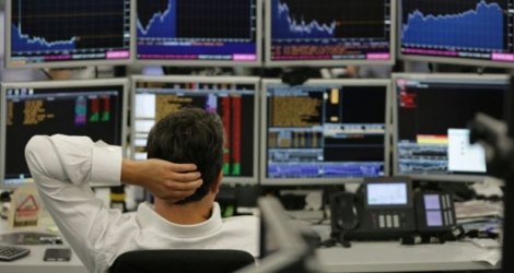 Un courtier de ETX Capital surveille sur écrans les cours boursiers, le 27 juin 2016 à Londres Photo Daniel LEAL-OLIVAS. AFP