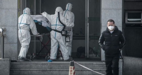 Du personnel médical transporte un malade à l'hôpital Jinyintan de Wuhan, où sont traités des patients infectés par un mystérieux virus, analogue au Sras, le 18 janvier 2020.
