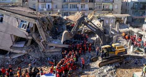 Des équipes de secours retirent des corps des décombres d'un immeuble effondré lors d'un puissant séisme, le 26 janvier 2020 à Elazig, en Turquie.