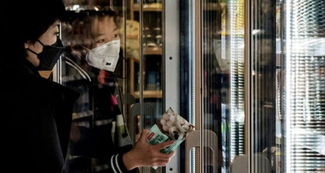 Des clients portent des masques de protection dans un supermarché de Pékin, le 28 janvier 2020.