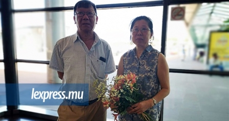 Le couple Lai, bouquet en main, attend patiemment que leur fils leur revienne à l’aéroport ce lundi 17 février.
