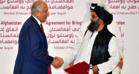 (G à D) Le représentant spécial américain Zalmay Khalilzad et le chef politique des talibans afghans Abdul Ghani Baradar se serrent la main après la signature d'un accord le 29 février 2020 à Doha Photo Giuseppe CACACE. AFP