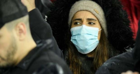 Une supporter de football porte un masque de protection au stade Santiago Bernabeu de Madrid le 1er mars 2020