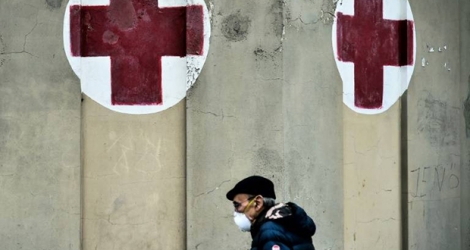 Un homme portant un masque de protection passe devant l'entrée de l'hôpital Molinette à Turin, le 9 mars 2020 en Italie.