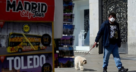 Un Espagnol promène son chien dans les rues de Madrid le 14 mars 2020.