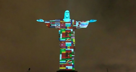 Projection des drapeaux de tous les pays infectés par le coronavirus, sur le Christ rédempteur de Rio de Janeiro, le 18 mars 2020.